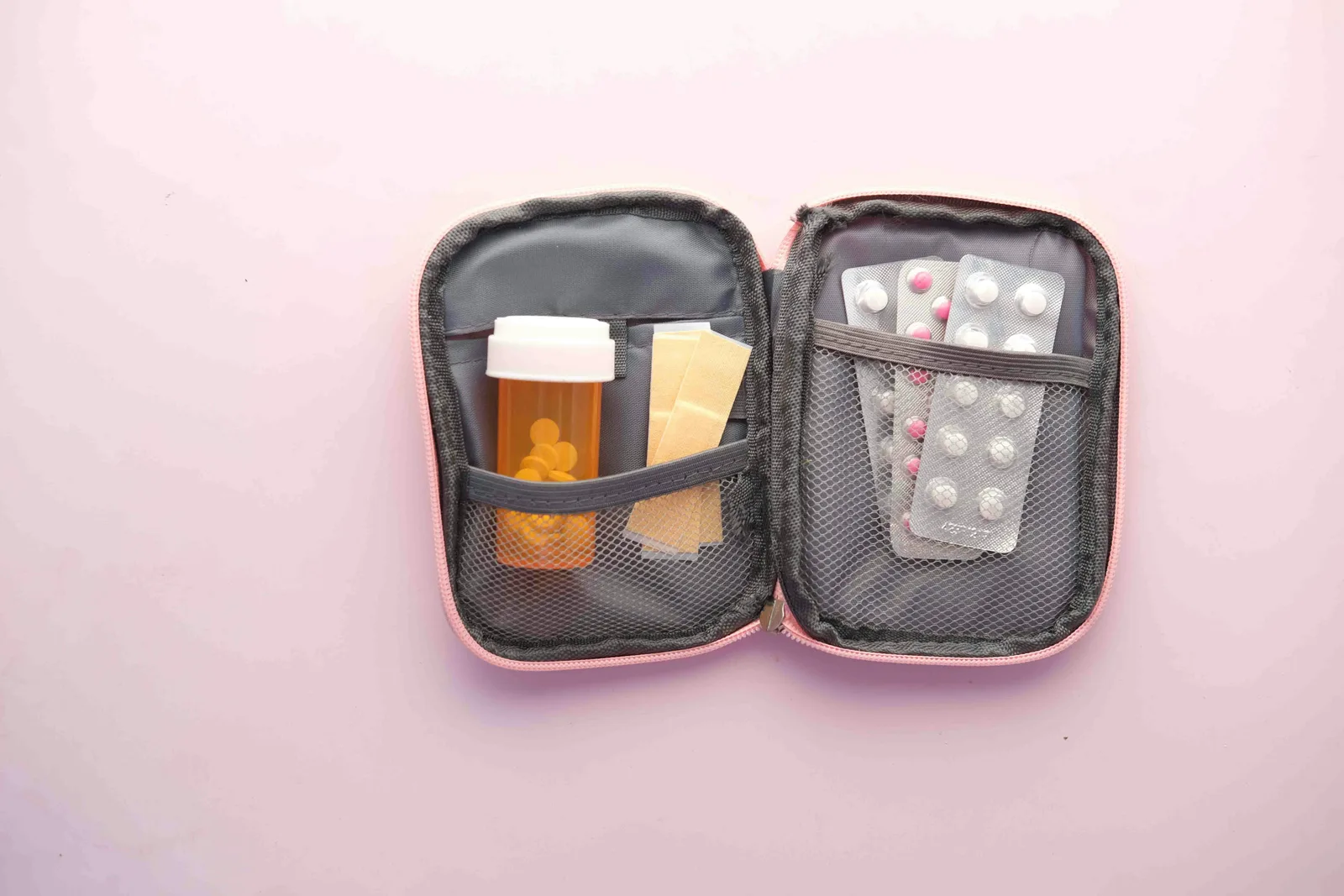 Open compact first aid case with packaged bandages and medicine containers